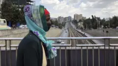 ጭምብል ያጠለቀች ሴትዮ
