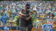 Tres personas abrazándose en un cementerio de Brasil