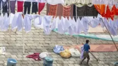 बांग्लादेश में कपड़े साफ़ करते धोबी