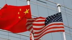 A US and a Chinese flag wave outside a commercial building in Beijing