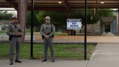 Dos agentes en la puerta de la escuela Robb de Uvalde