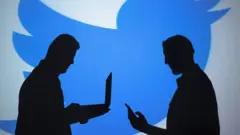 El perfil de dos hombres con lapton y celular frente a un logo de Twitter