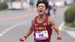 He Jie celebrates winning the marathon at the 2023 Asian Games