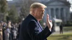 President Donald Trump waves as he walks to Marine One on the South Lawn of the White House on 12 January