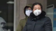Gente con mascarillas en Wuhan