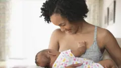 Mère allaitant son bébé dans le salon