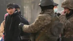 Военные проверяют документы у прохожего