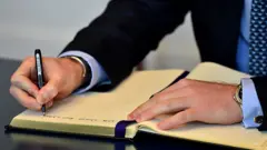 Prince Harry signs book