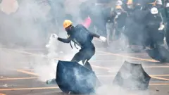 Protester throwing a tear gas can back at the police