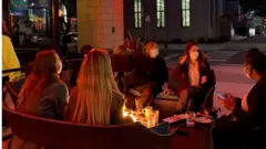 People sit outside at a table at Fat Cat bar in Chicago