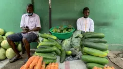 Fruit sellers practice social distancing as they wait for customers on the first day of the easing of the lockdown measures.