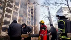 Bombeiros e voluntários removem escombros após ataque aéreo russo em Kiev