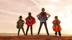Siblings dressed as superheroes