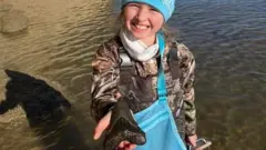 Molly poses with her megalodon tooth