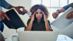 Imagen de una mujer que parece estar sobrecargada de trabajo.