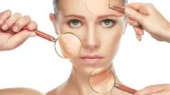 Lupa sobre el rostro de una mujer, mostrando sus arrugas.