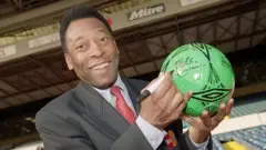 Pelé autografando bola de futebol