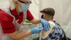 A man being vaccinated with the Oxford-AstraZeneca vaccine