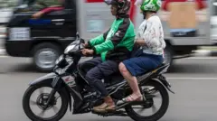 A picture of two people riding a motorbike