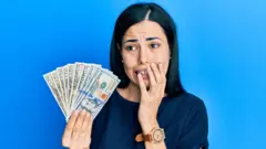 Mujer asustada con dinero