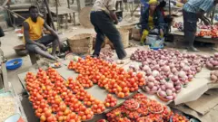 Awọn ọlọja tomato ati alubọsa duro ti ọja wọn