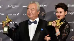 Hong Kong actress Kara Hui Ying-hung (R) poses with Chinese actor Tu Men (L) at the Golden Horse Awards