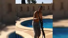 در تصاویر گوشی هوشمند، شکری الخلیفی اهل لندن در حالی که با یک اسلحه کنار استخر ژست گرفته دیده می‌شود