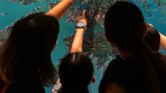 Personas señalan en el mapa.