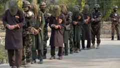 Afghan security forces with captured Taleban fighters