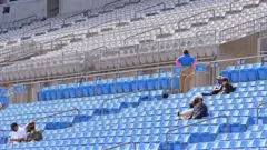 A limited number of fans arrive to stadium for the game