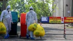 Funcionários de hospital usando equipamento de proteção na Índia