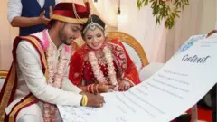 అగ్రిమెంట్ పై సంతకం చేస్తున్న కొత్త దంపతులు మింటూరాయ్, శాంతి ప్రసాద్