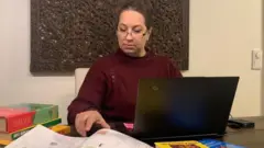 Ilona Taimela sentada en su laptop en casa