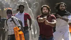 ఫిబ్రవరి 24 న మౌజ్‌పూర్ ప్రాంతానికి సమీపంలో పిస్టల్ ఎక్కుపెడుతున్న ఒక వ్యక్తి