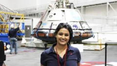 La Dra Varsha Jain frente a un módulo Orion en Centro Espacial Johnson de la NASA