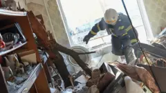 Ukrainian firefighters arrive to rescue civilians after an airstrike hit an apartment complex in Chuhuiv, Kharkiv Oblast, Ukraine on 24 February 2022