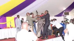 Sawir muujinaya labo xildhibaan oo baarlamaanka Kenya ka tirsan oo siu gacan qaadaya