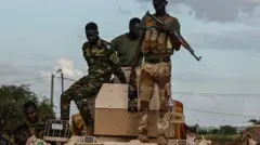 Des soldats nigériens montant un véhicule blindé