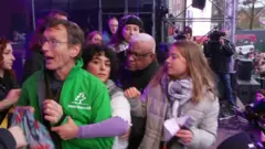 رجل يمسك بميكروفون غريتا تونبرغ بعد هتافات مؤيدة للفلسطينيين