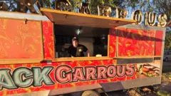 Mulher dentro de um trailer de comida