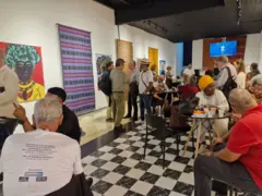 Várias pessoas sentadas em um espaço conversando.