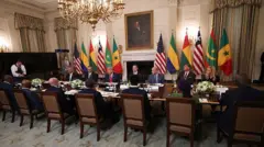 Le président américain Donald Trump (C) s'exprime lors d'un déjeuner multilatéral avec des dirigeants africains en visite dans la salle à manger d'État de la Maison Blanche à Washington, DC, le 9 juillet 2025. 