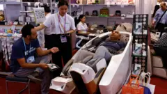 一個男人在廣交會上體驗按摩椅產品