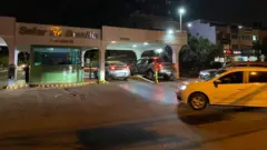 A entrada do condomínio Solar de Brasília, onde Bolsonaro vive, com carros entrando.