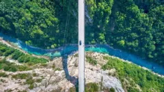 Carro passando sobre ponte no desfiladeiro do rio Tara, em Montenegro