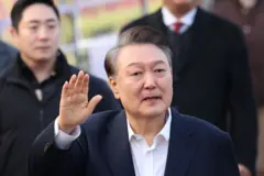 윤석열 대통령이 8일 서울구치소에서 걸어나오며 지지자들에게 인사를 하고 있다