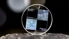 Cristal de vidro da SPhotonix, mostrando imagens digitais de uma pintura da caverna de Chauvet, na França, e uma imagem gerada por IA de uma alunissagem, colocado em órbita em junho de 2025.