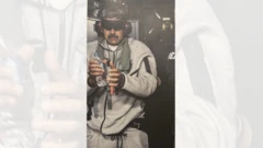 Maduro esposado y con los ojos tapados, de ropa deportiva gris y con una botella de plástico transparente en una de sus manos.