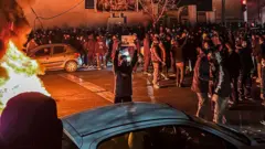 Um grupo de iranianos bloqueia uma rua durante protesto em Teerã