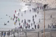Vários migrantes tentam atravessar a fronteira a nado em 30 de julho de 2026, em Ceuta.